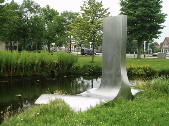 Een groot, glanzend roestvrijstalen kunstwerk in het water, met een golvend, organisch gevormd platform dat lijkt op een gestileerd blad of een gestold vel metaal, waaruit een hoog, gebogen verticaal element omhoog steekt.